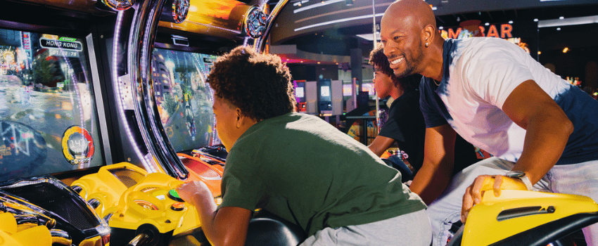 A man celebrates his son's birthday with a free game at Dave & Buster's, taking advantage of the Dave & Busters birthday reward.