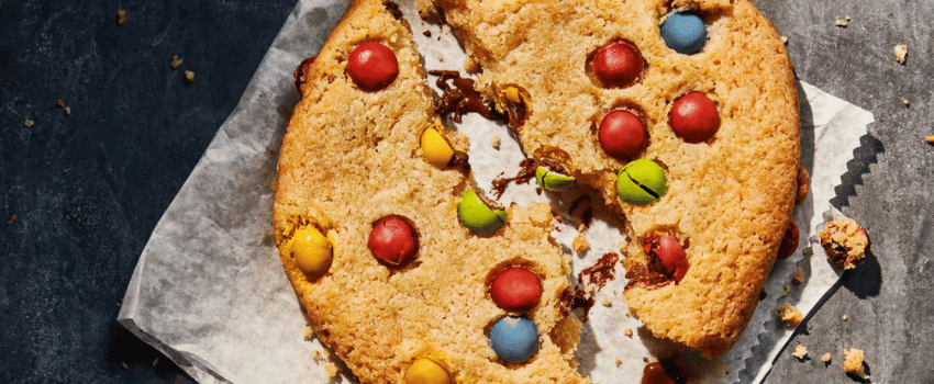 A cookie topped with vibrant candies, representing Panera Bread's birthday reward.